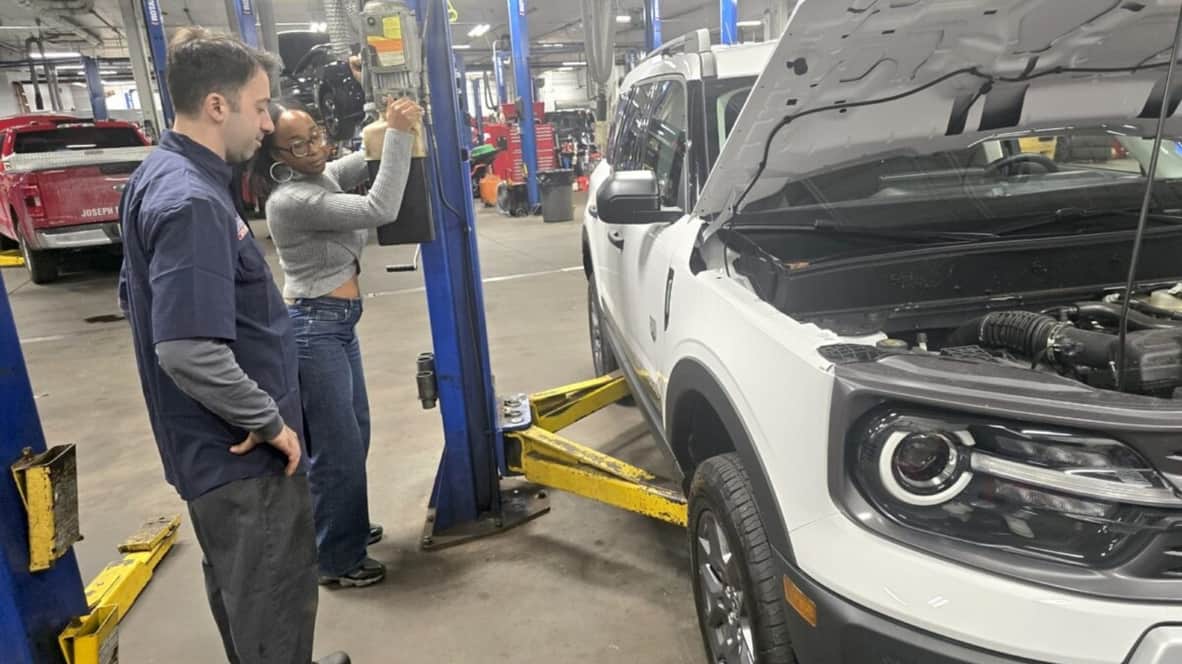 Kim Standing With A Ford Technician