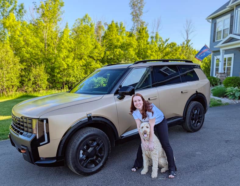 Shannon standing with her dog in front of the 2027 Kia Telluride X-Pro SX Prestige