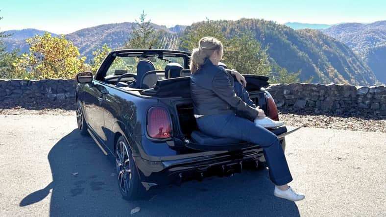 Scotty Reiss overlooking a scenic landscape from the back of a mini cooper JCW