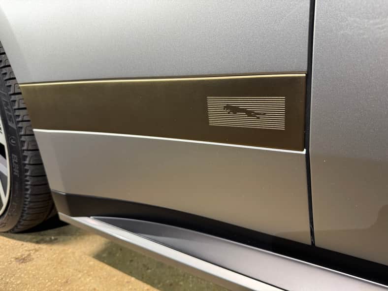 A brass panel on the exterior of the Jaguar Type 01 features a classic Jaguar Leaper