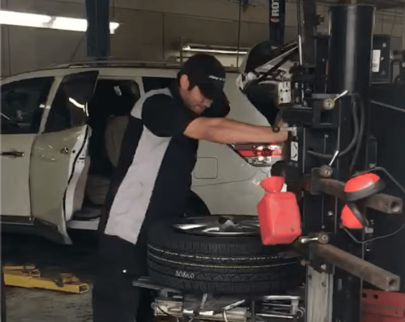 The technician at Excalibur Auto Repair installing my new tires